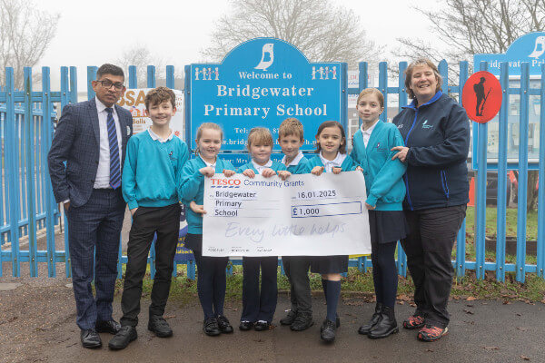 Yassas Jayasinghe Tesco Northchurch Express Store Manager presents the cheque to pupils at Bridgewater School and their Headteacher Andrea Bettridge