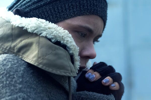 Living Magazines DENS Winter appeal. Image shows Female beggar feeling cold outdoors, homelessness problem, poverty despair