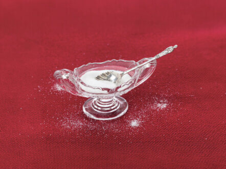 Table salt crystals in cut glass bowl on red tablecloth