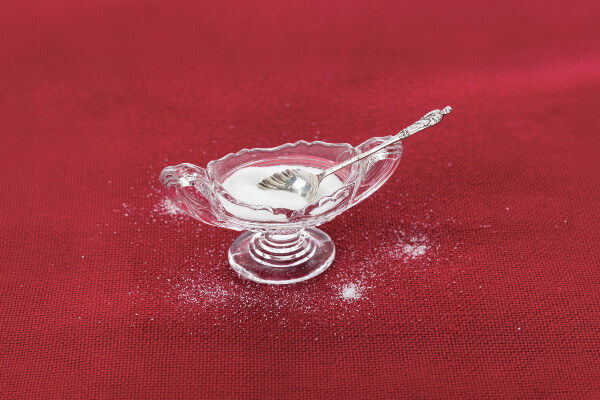 Table salt crystals in cut glass bowl on red tablecloth