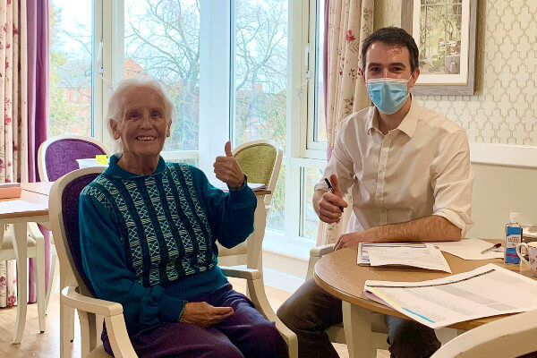 Living Magazines Jean Bamford - Resident at Hampden Hall Care Centre recieves her first COVID vaccine from Dr Mike Thomas