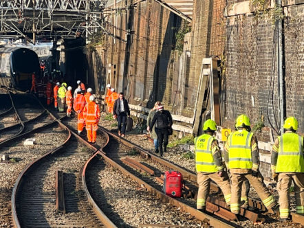 Living Magazines Network Rail teams and emergency services helping passengers off stranded train outside Euston station