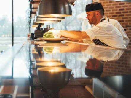 Living Magazines Oakman Inns - chef putting final touches to dish in open kitchen