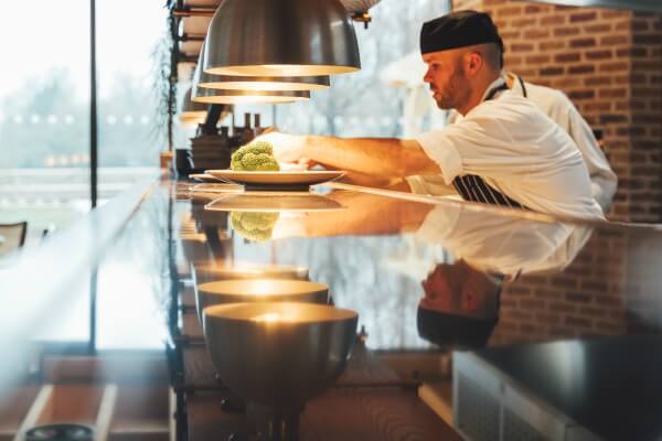 Living Magazines Oakman Inns - chef putting final touches to dish in open kitchen