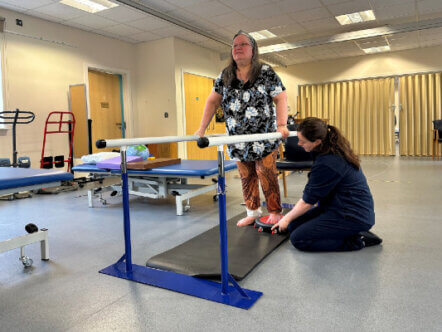 Penny Munro being supported by Lucy Sharpe, one of the physios at the Chilterns Neuro Centre