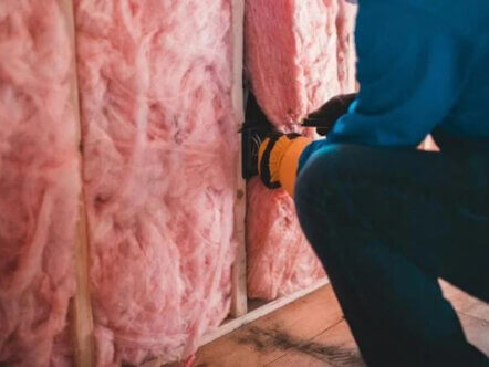 Person installing wall insulation