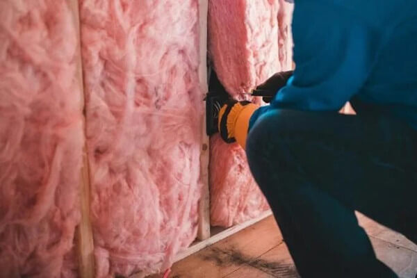 Person installing wall insulation