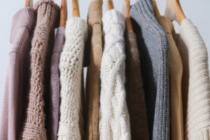 Sweaters hanging on rail