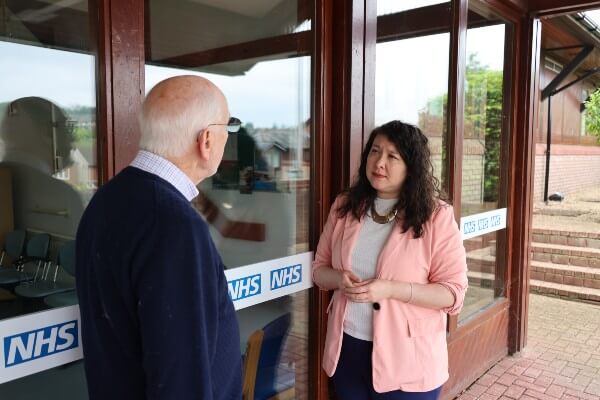 Victoria Collins MP speaking to a constituent outside a GP surgery