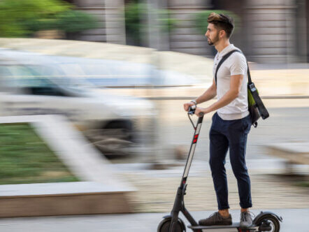 Living Magazines Young man riding an e-scooter