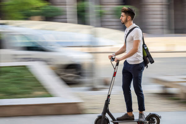 Living Magazines Young man riding an e-scooter