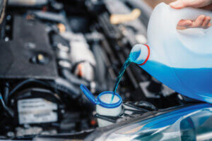 Pouring antifreeze. Filling a windshield washer tank with an antifreeze in winter cold weather.