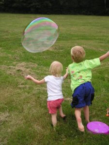 Living Magazines kids-chase-a-bubble-at-a-family-picnic