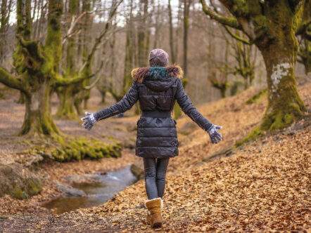 Living Magazines young woman walking in forest