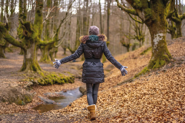 Living Magazines young woman walking in forest